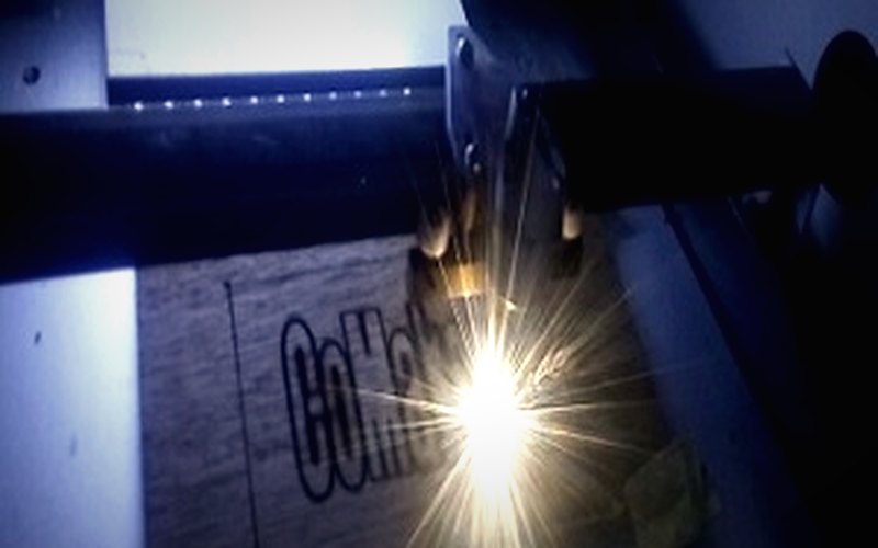Laser cutter engraving the CoMakers name